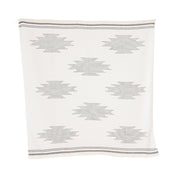 A handloomed alpaca throw with a geometric pattern in ink and ivory colors.