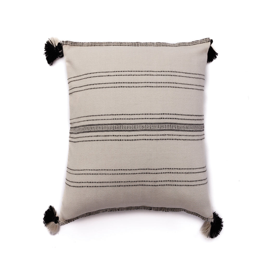 A handloomed alpaca wool pillow with ink and ivory pinstripe pattern and black pom poms on the corners.