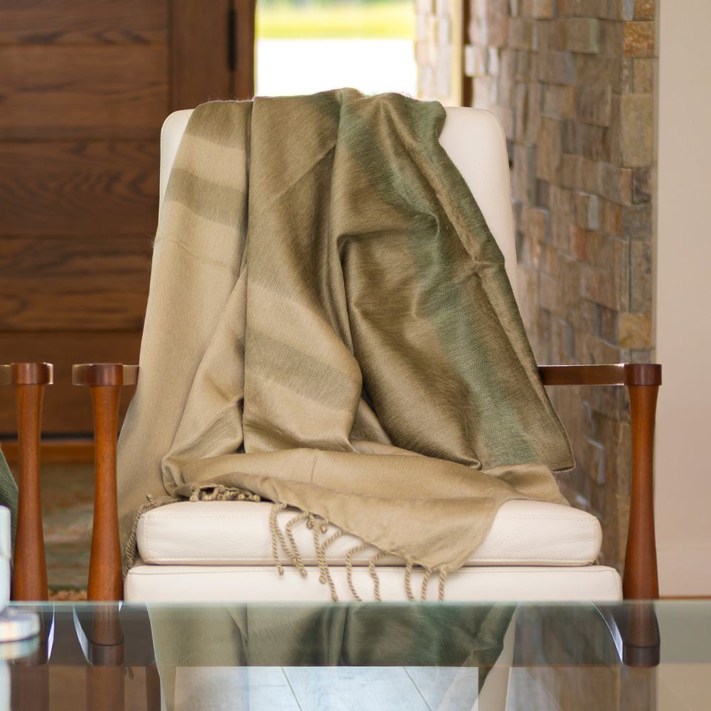 green and beige throw blanket on white accent chair