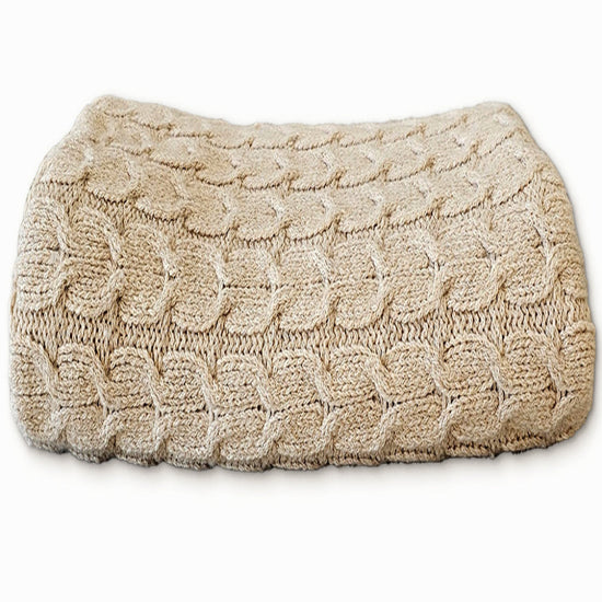 Beige knitted eye pillow on a white background