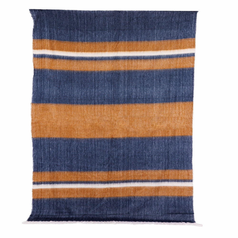 A striped throw blanket with denim blue, copper, and white colors, featuring a 4-inch white fringe on the long ends.