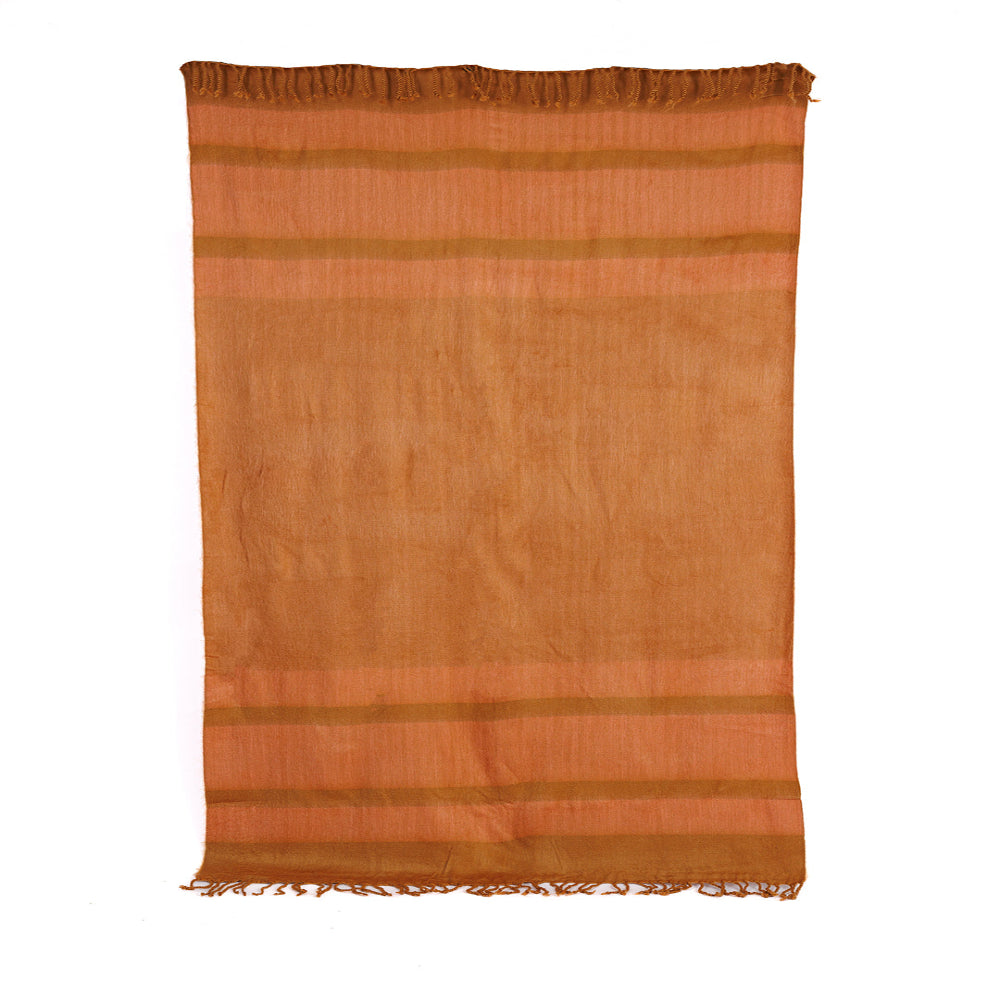 A copper and coral colored throw blanket with hand-tied tobacco colored fringe on the long ends, displayed against a plain background.