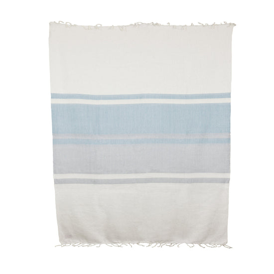 A striped throw blanket with white, bluish gray, and gray horizontal stripes, featuring hand-tied natural fringe on the long ends.