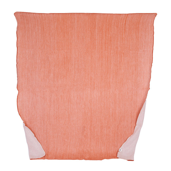 A reversible melon and white throw blanket woven from alpaca yarns, displayed flat.