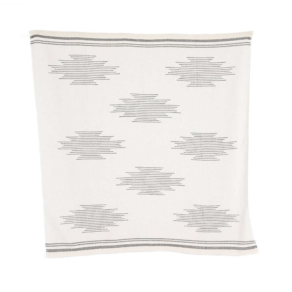 A handloomed alpaca throw with a geometric pattern in ink and ivory colors.