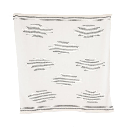 A handloomed alpaca throw with a geometric pattern in ink and ivory colors.