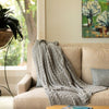gray cable knit throw blanket on beige sofa