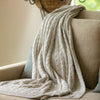 Light grey artisanal woven throw on sofa
