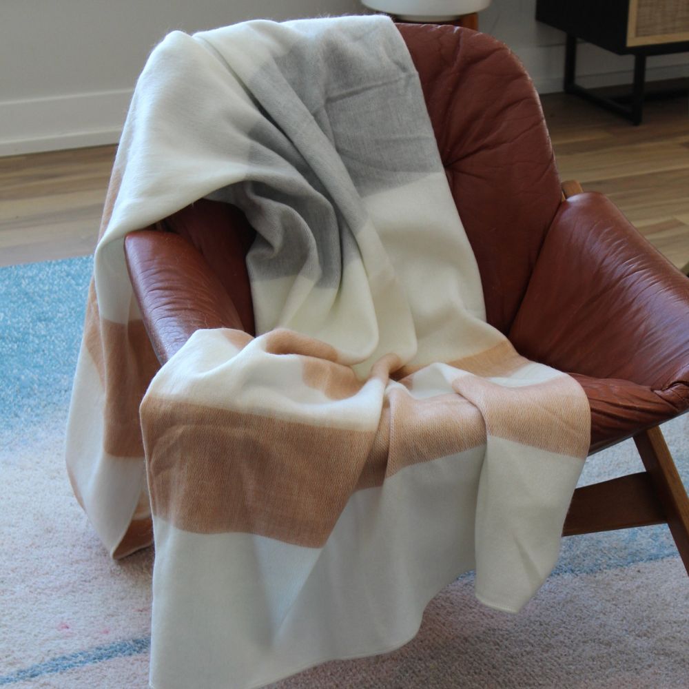 A soft blanket resting on a chair in a stylish living room setting.