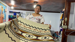 Person holding intricate woven textile in colorful craft workshop setting