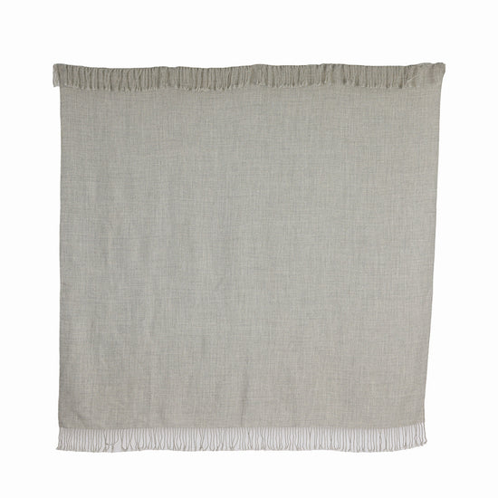 A graphite gray baby alpaca throw with fringes, handwoven and displaying the natural texture of the fiber.
