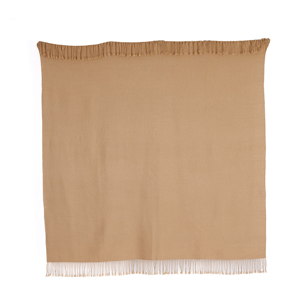 A light tan baby alpaca throw with fringes, handwoven and displaying natural fiber texture.