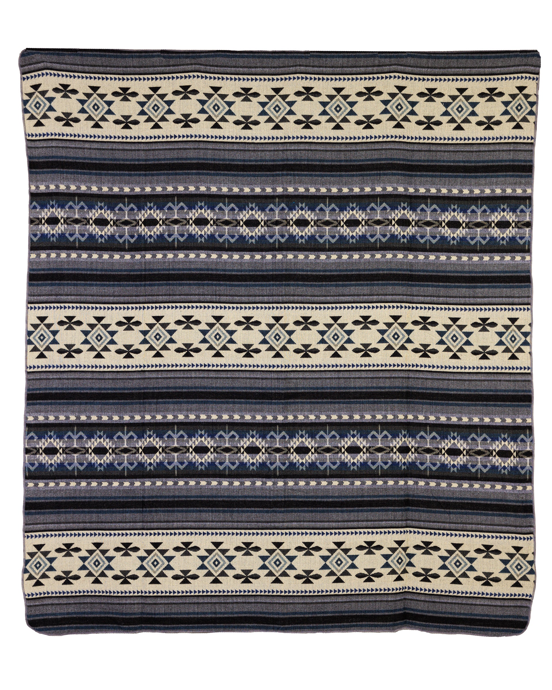 A geometric patterned throw blanket in shades of blue, gray, and cream, with a reversible design showing a light cream side with gray and deep blue accents.
